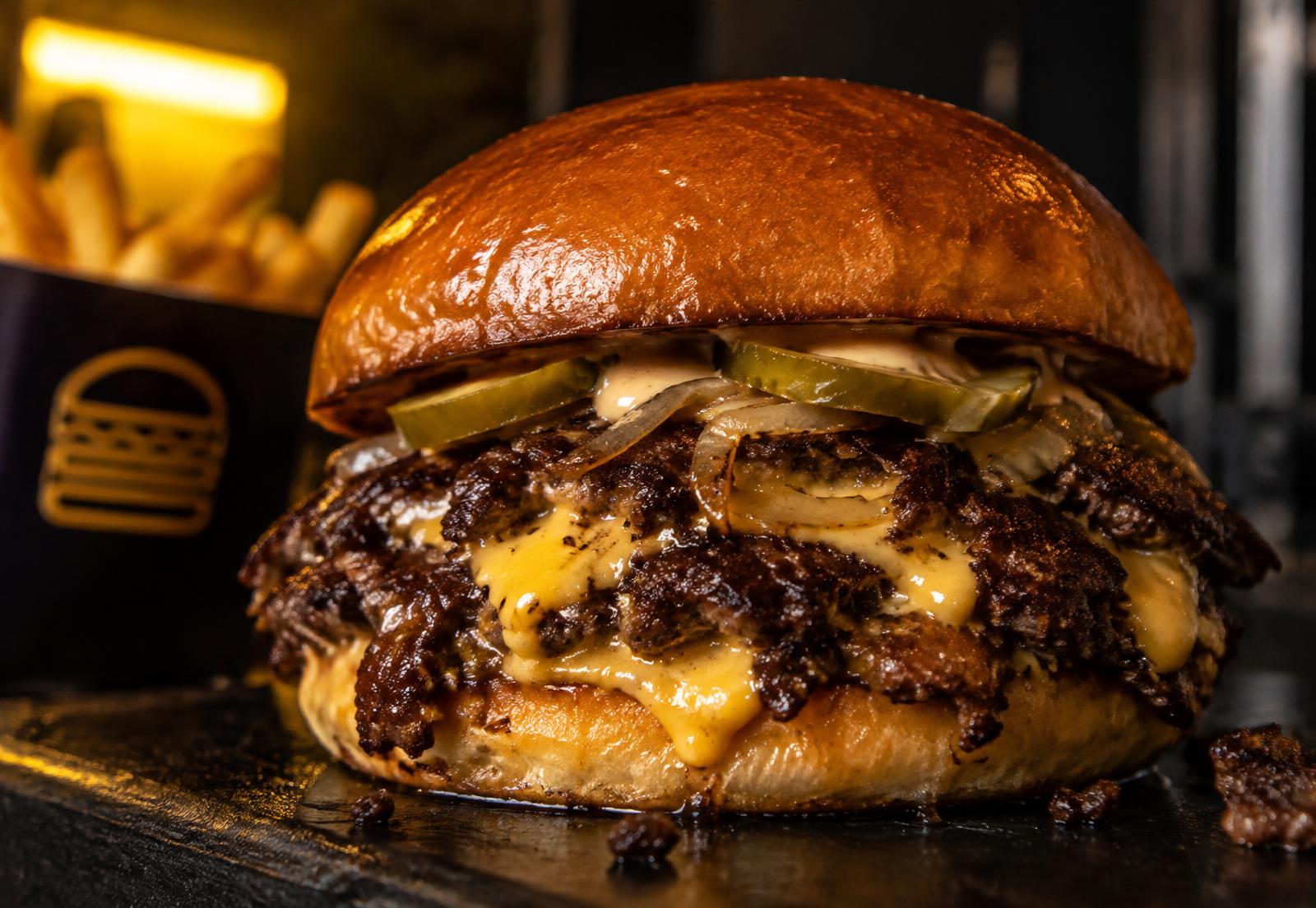 Smash burger com crosta tostada e queijo derretido (imagem ilustrativa)